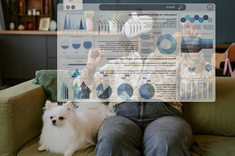 Woman using virtual reality headset for remote work while sitting on green couch with white dog next to her